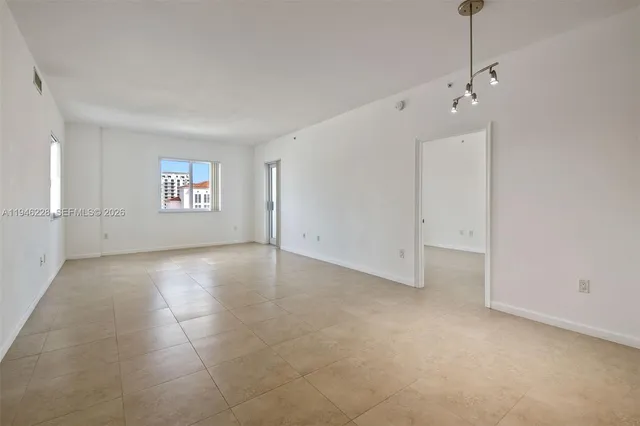 a view of empty room with kitchen
