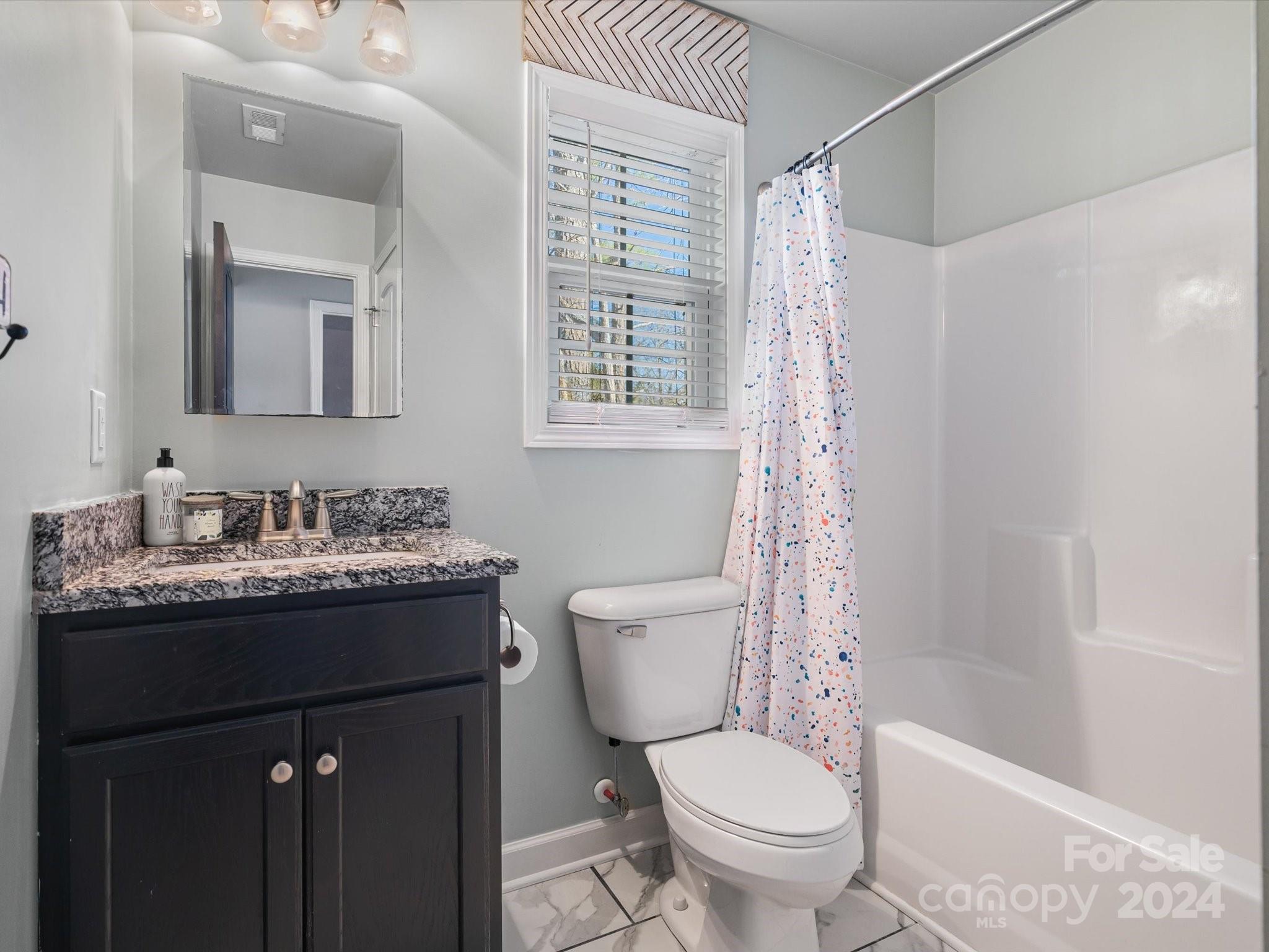 1128 State Rd S-46-817 York, SC 29745 - Photo 16 of 22 a bathroom with a granite countertop sink toilet a mirror a vanity and shower