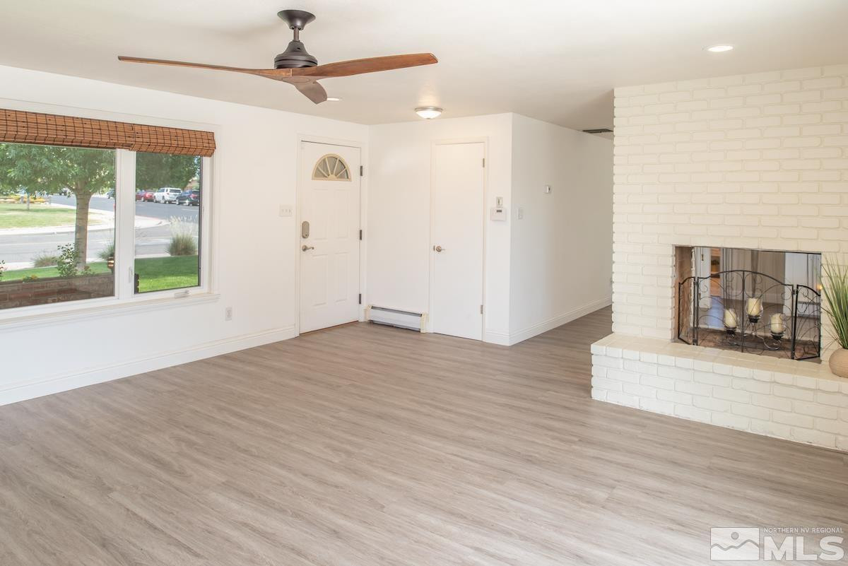3900 Warren Way Reno, NV 89509 - Photo 11 of 29 a view of a livingroom with wooden floor a ceiling fan and windows