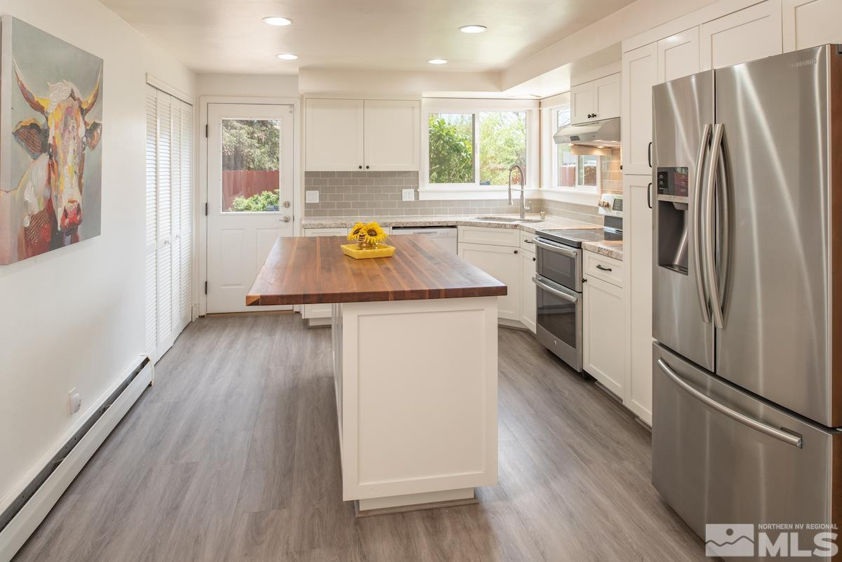 3900 Warren Way Reno, NV 89509 - Photo 13 of 29 a kitchen with a refrigerator a sink and wooden floor