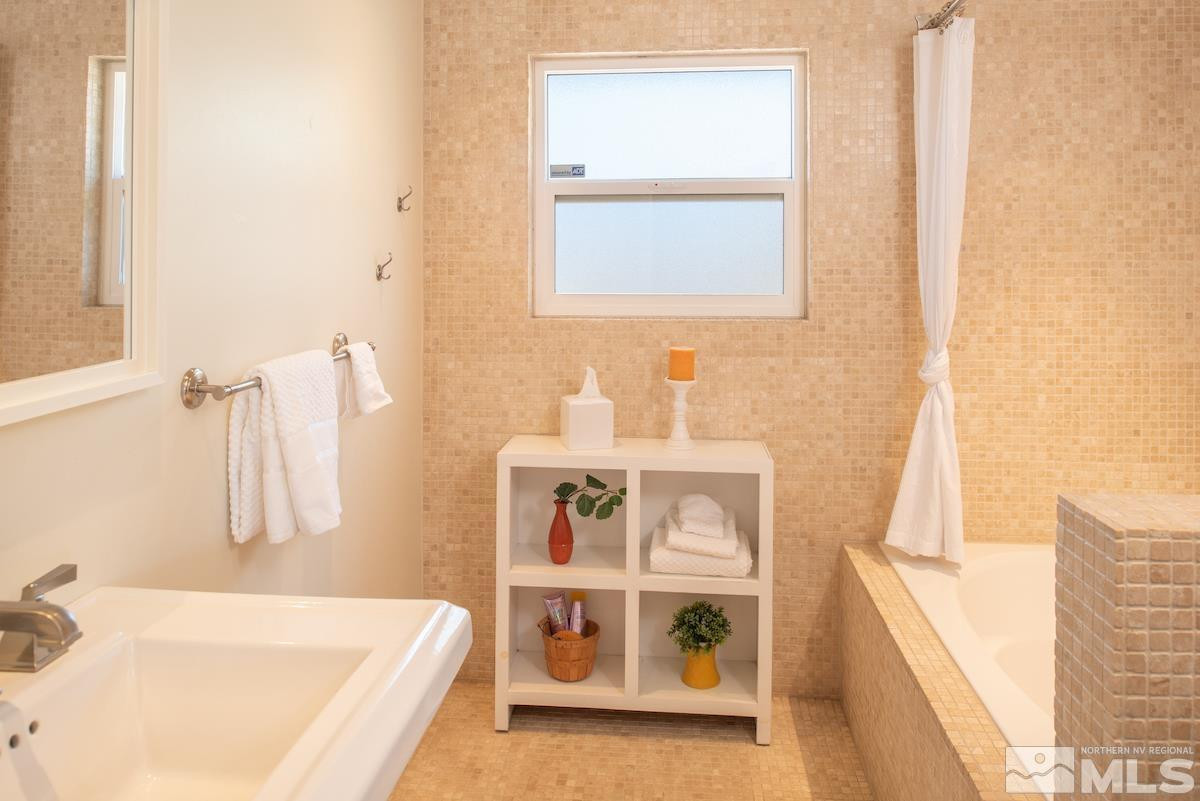 3900 Warren Way Reno, NV 89509 - Photo 23 of 29 a bathroom with a tub sink and a window