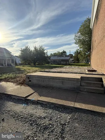 a view of a yard with wooden fence