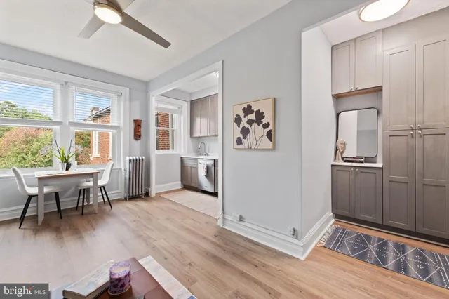 a kitchen with stainless steel appliances a stove a sink dishwasher a microwave oven with a dining table and chairs