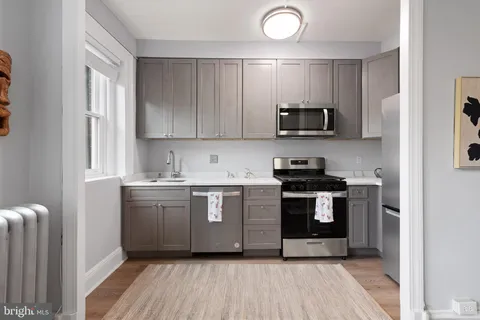a kitchen with stainless steel appliances granite countertop a sink stove and microwave