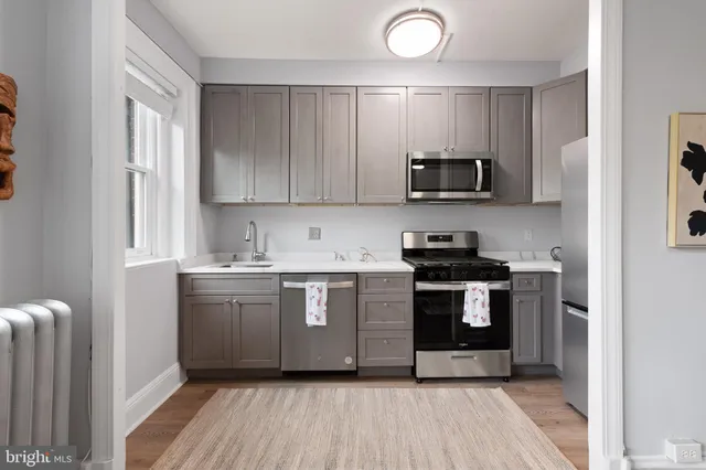 a kitchen with stainless steel appliances granite countertop a sink stove and microwave