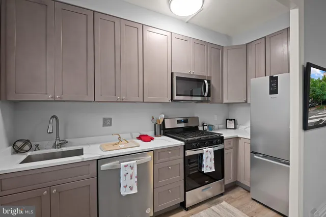 a kitchen with stainless steel appliances granite countertop a sink stove and microwave