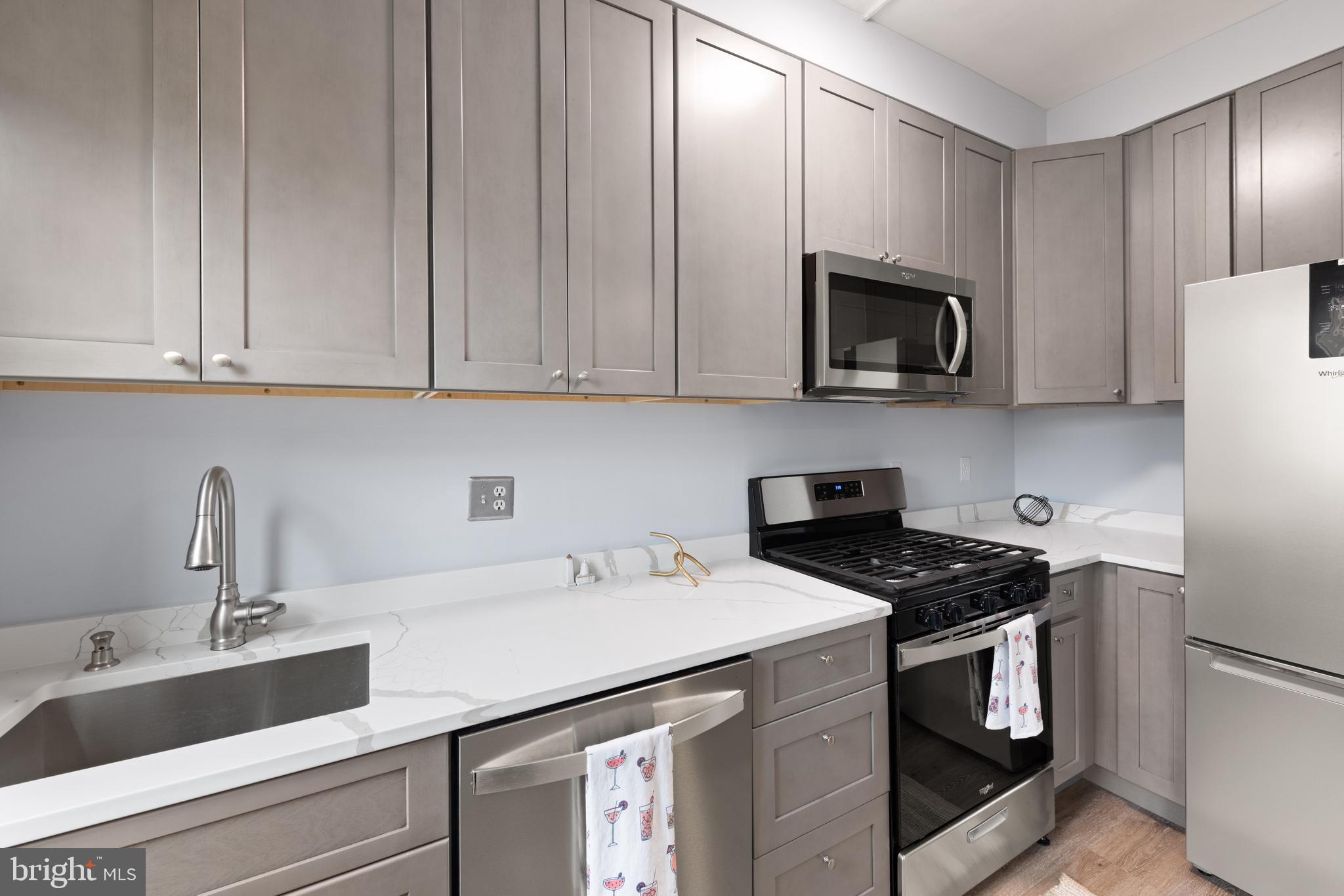 2456 20th Street Northwest, Unit 507 Washington, DC 20009 - Photo 24 of 42 a kitchen with stainless steel appliances granite countertop a sink stove and microwave