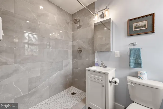 a bathroom with a sink vanity mirror and toilet