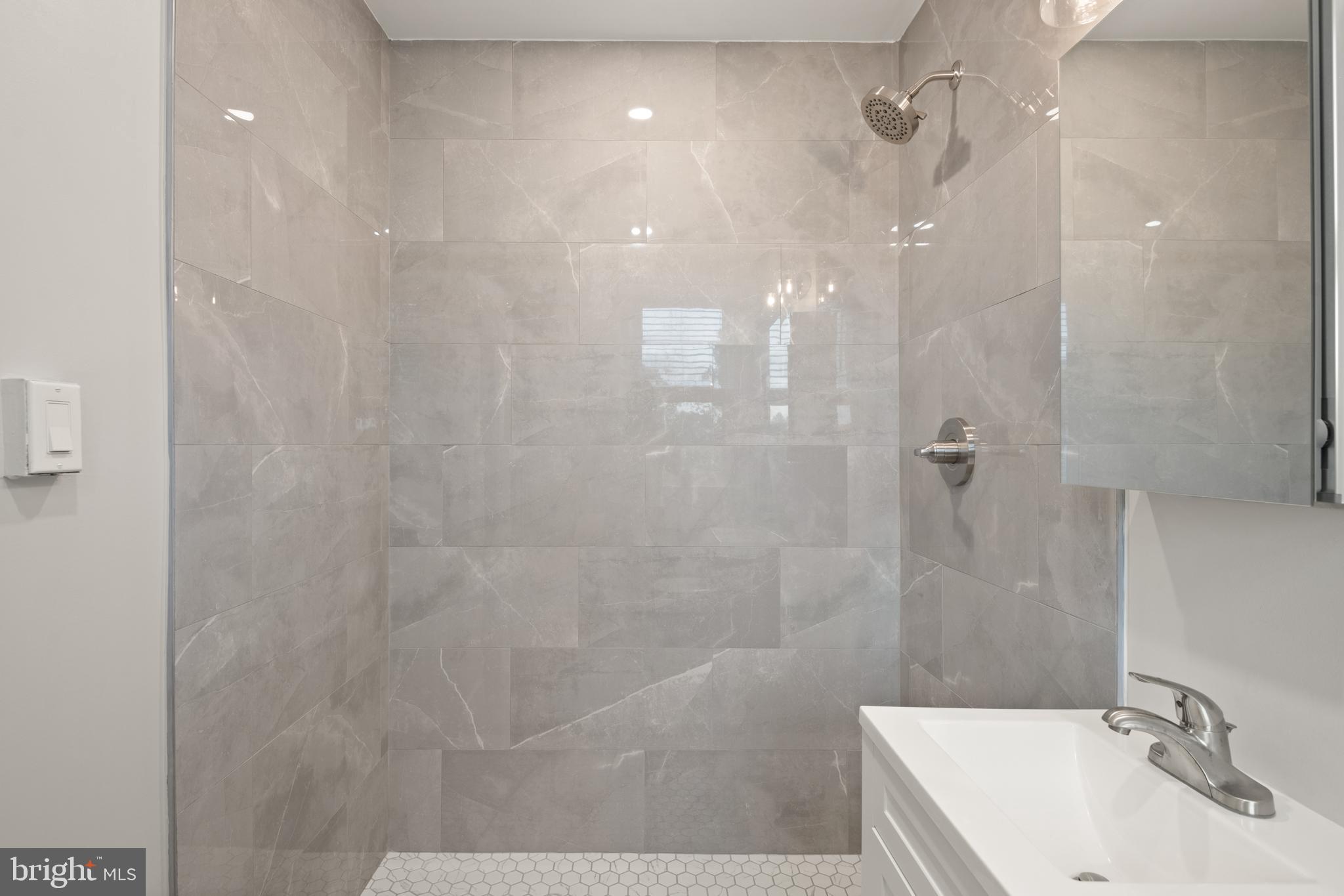 2456 20th Street Northwest, Unit 507 Washington, DC 20009 - Photo 36 of 42 a bathroom with a sink a shower and a mirror