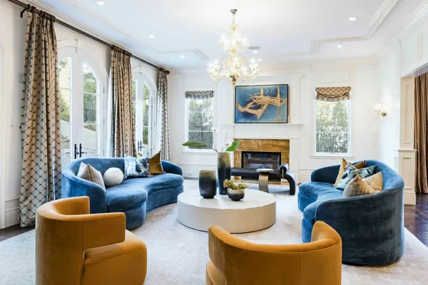 a living room with furniture chandelier and a large mirror