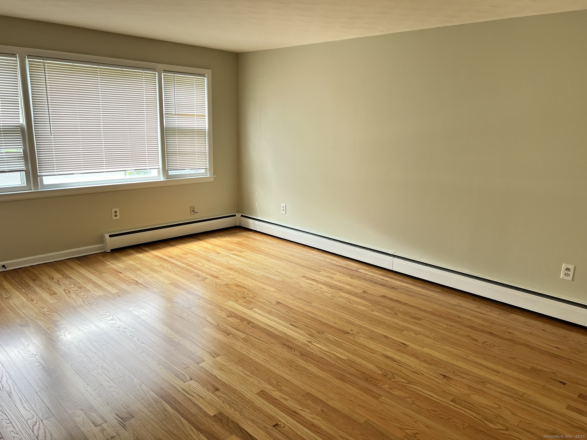 138 Carroll Street New Britain, CT 06053 - Photo 2 of 8 an empty room with wooden floor and windows