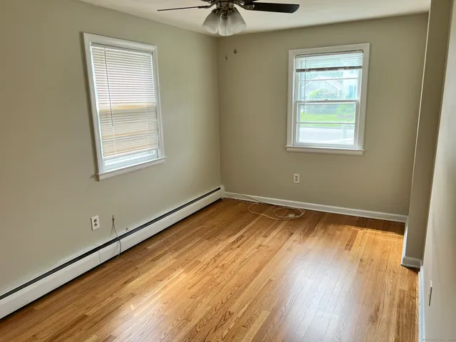 a view of a room with a window and wooden floor