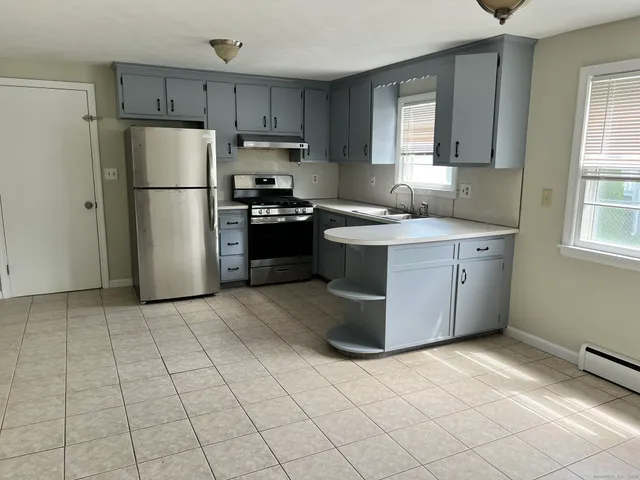 a kitchen with stainless steel appliances granite countertop a refrigerator stove top oven and sink