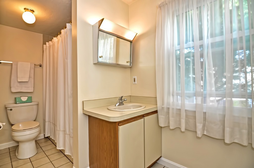 15 Church Street, Unit 2 Natick, MA 01760 - Photo 10 of 14 a bathroom with a granite countertop sink a toilet and a mirror