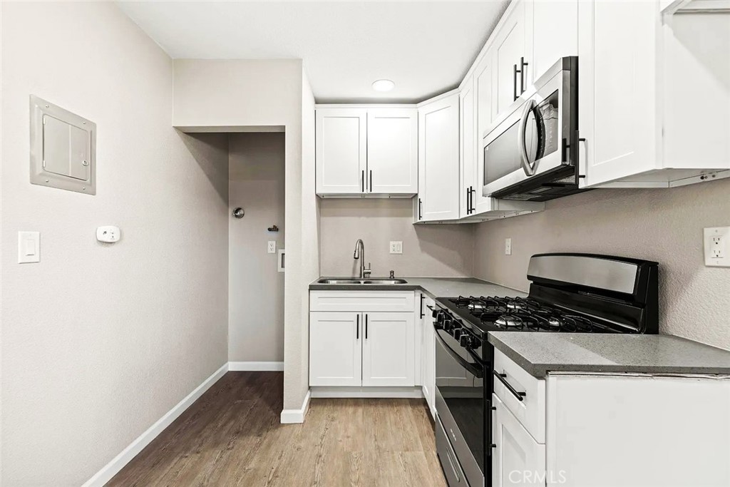 44532 Andale Avenue Lancaster, CA 93535 - Photo 14 of 21 a kitchen with granite countertop cabinets stainless steel appliances and wooden floor