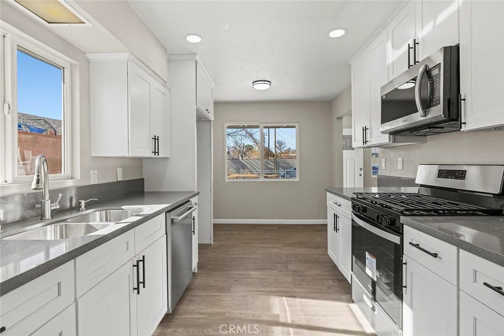44532 Andale Avenue Lancaster, CA 93535 - Photo 8 of 21 a kitchen with stainless steel appliances granite countertop a stove a sink and a microwave