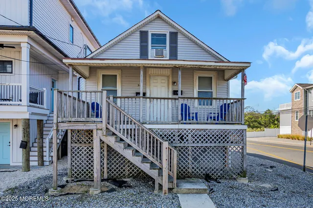 a view of a house with wooden deck and furniture