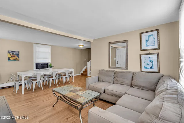 a living room with furniture wooden floor and dining table
