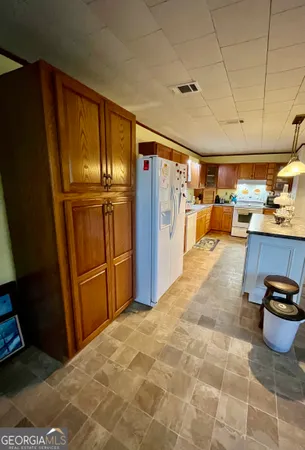 a kitchen with stainless steel appliances granite countertop a refrigerator a stove and a sink