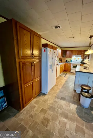 a kitchen with stainless steel appliances granite countertop a refrigerator a stove and a sink