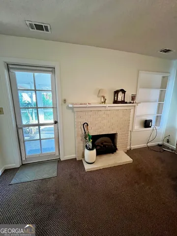 a view of an empty room with window and fireplace