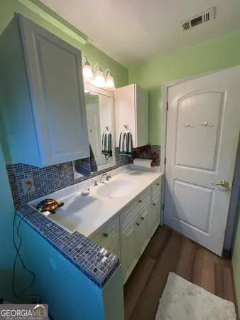 a bathroom with a granite countertop sink and a mirror
