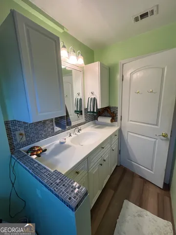a bathroom with a granite countertop sink and a mirror