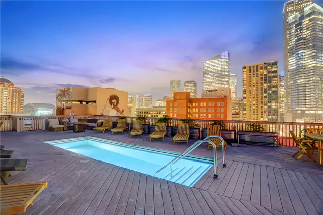 a view of a rooftop deck with chairs and wooden floor