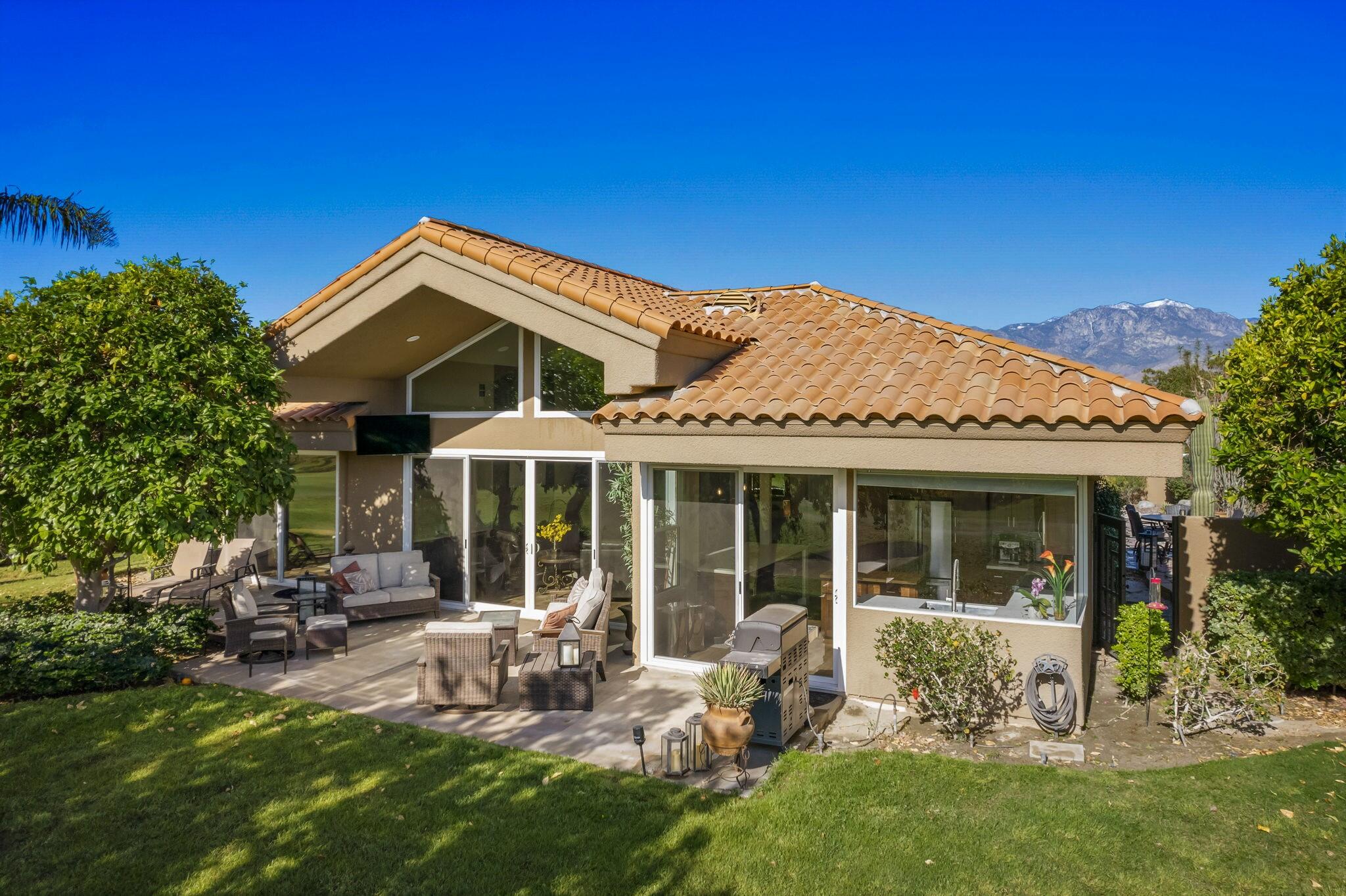 a view of a house with a yard potted plants and a table