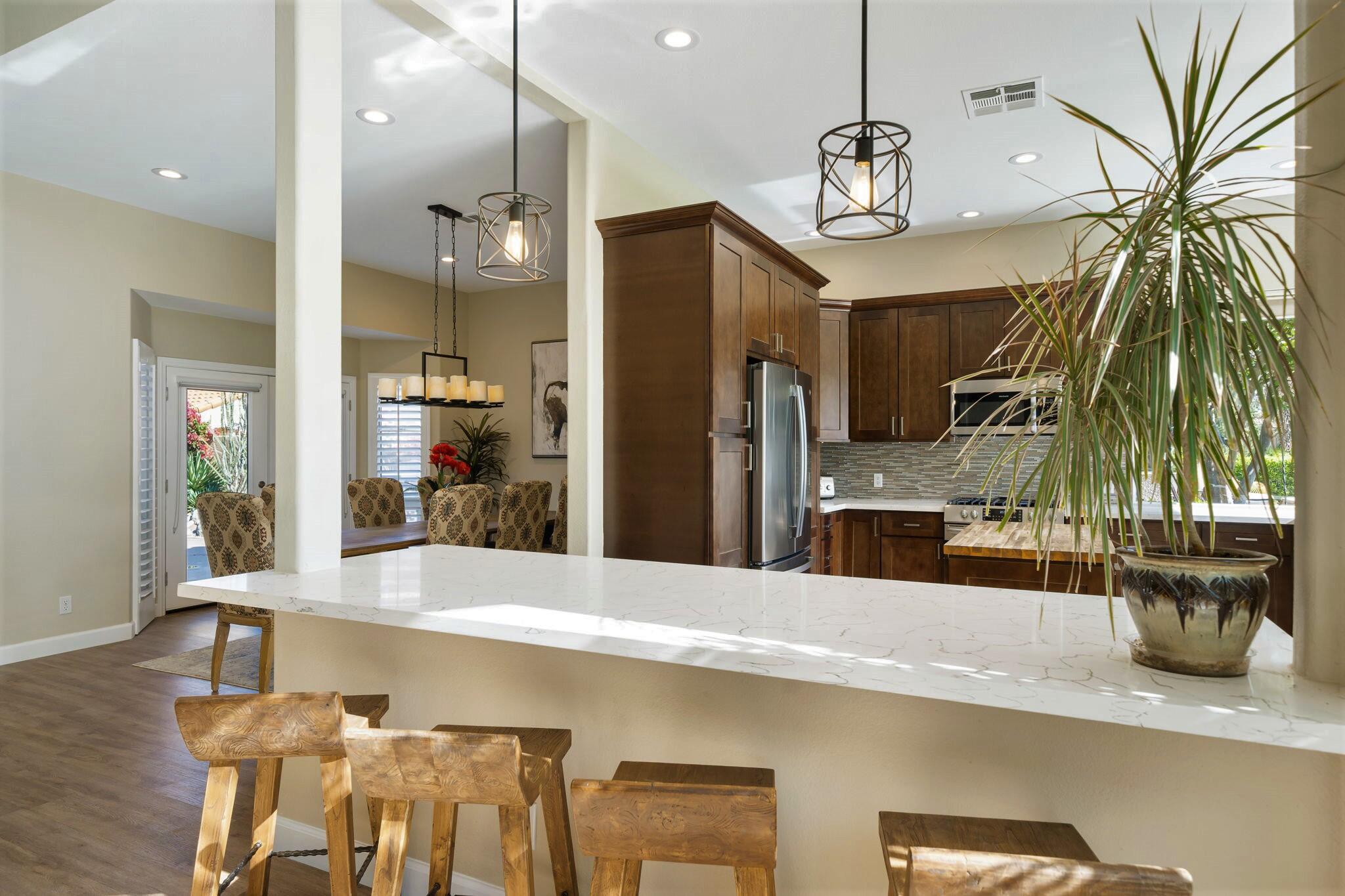 33 Colonial Drive Rancho Mirage, CA 92270 - Photo 20 of 62 a kitchen with stainless steel appliances kitchen island granite countertop a refrigerator a oven a sink and a dining table with wooden floor
