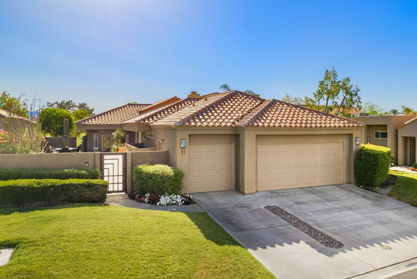 33 Colonial Drive Rancho Mirage, CA 92270 - Photo 2 of 62 a front view of a house with a yard and garage