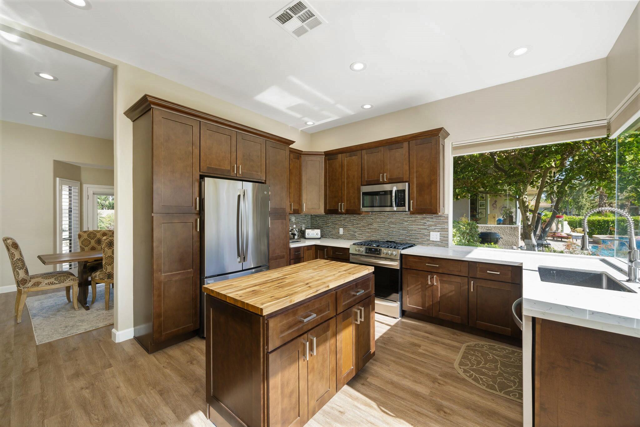33 Colonial Drive Rancho Mirage, CA 92270 - Photo 23 of 62 a kitchen with stainless steel appliances granite countertop sink stove top oven and refrigerator