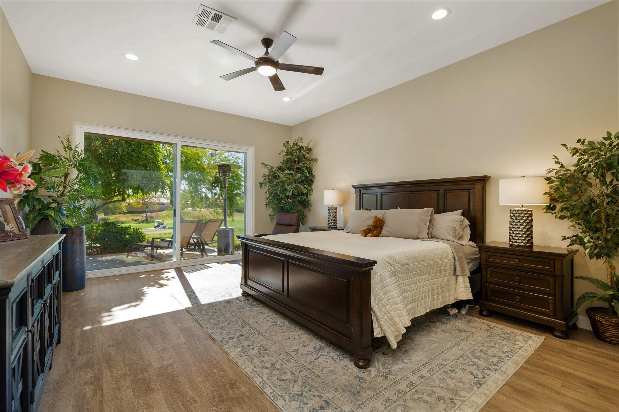 33 Colonial Drive Rancho Mirage, CA 92270 - Photo 26 of 62 a spacious bedroom with a bed a chandelier and a window