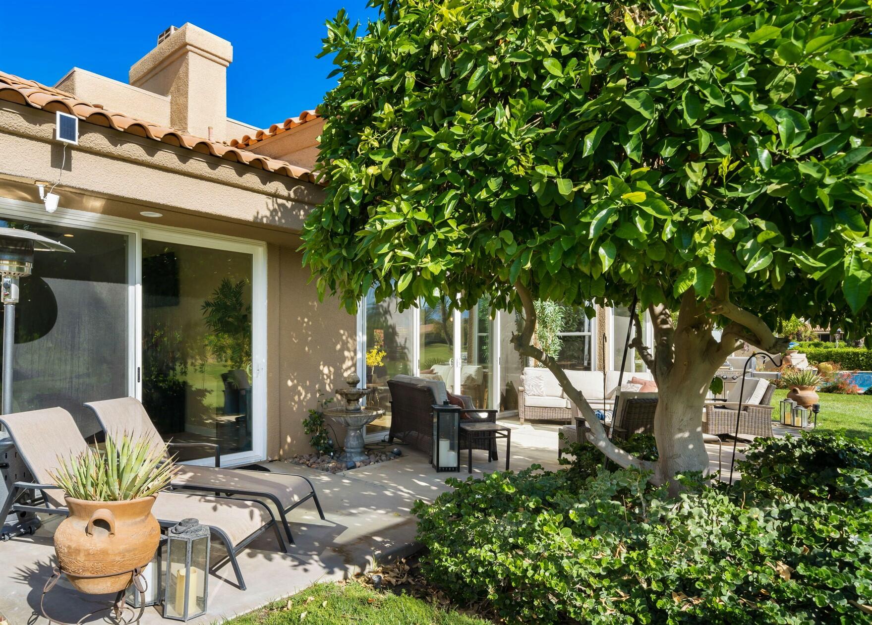 33 Colonial Drive Rancho Mirage, CA 92270 - Photo 46 of 62 a view of a patio with table and chairs potted plants and large tree