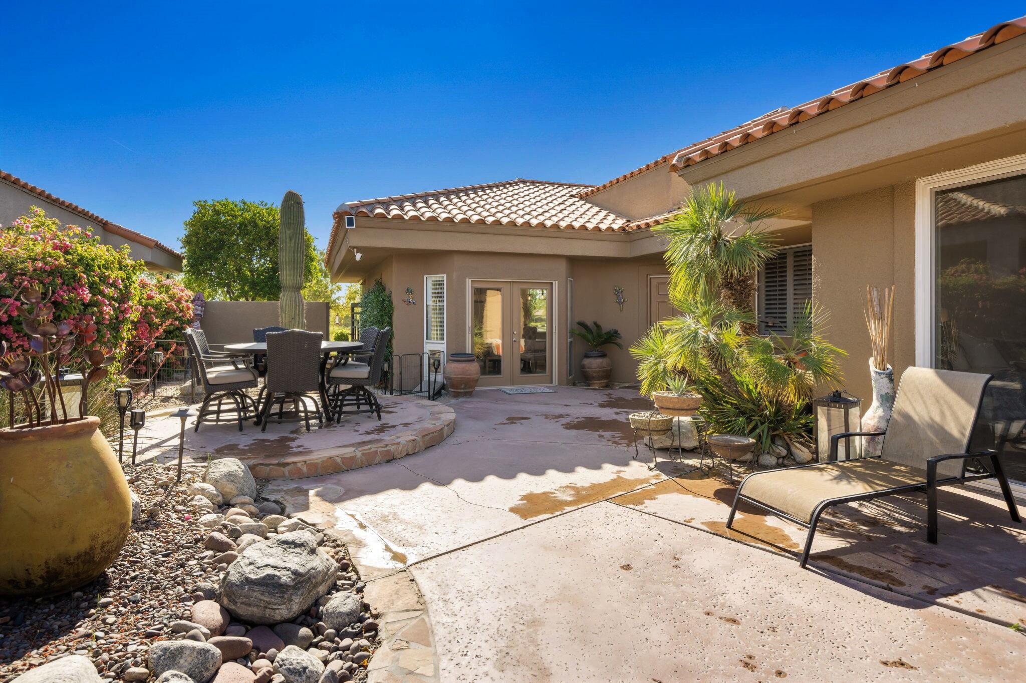 33 Colonial Drive Rancho Mirage, CA 92270 - Photo 6 of 62 a view of a patio with table and chairs potted plants and floor to ceiling window