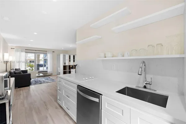 a kitchen with a sink dishwasher and a stove with wooden floor