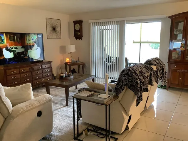 a bedroom with a bed and a flat tv screen on dresser