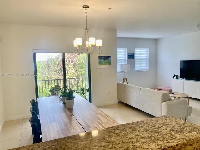 a living room with furniture chandelier and a flat screen tv
