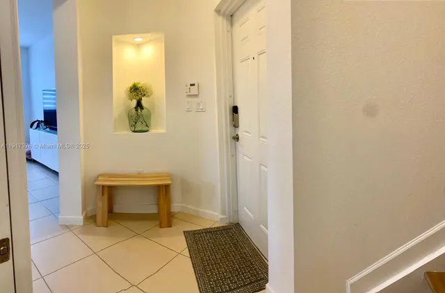 a view of a hallway with wooden floor and a bathroom