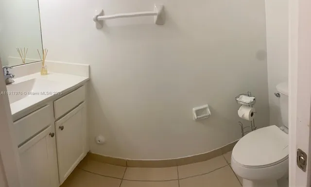a bathroom with a granite countertop toilet and a sink