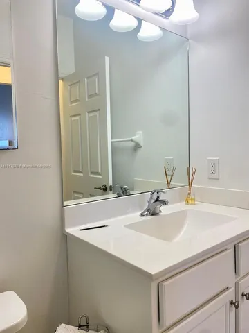 a bathroom with a sink and a mirror with toilet