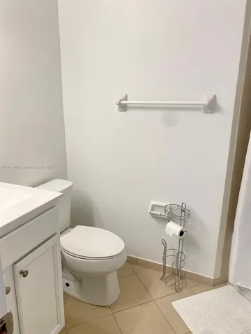 a white toilet sitting next to a shower
