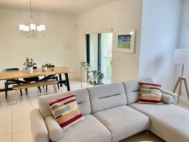 a living room with furniture and a chandelier