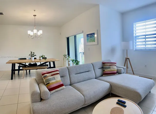 a living room with furniture chandelier and a table