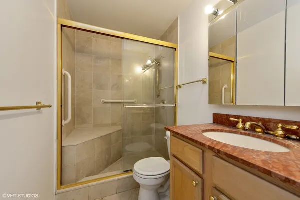 a bathroom with a granite countertop sink toilet and shower