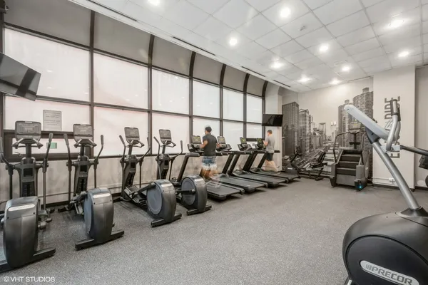 a living room with furniture gym equipment and a large window