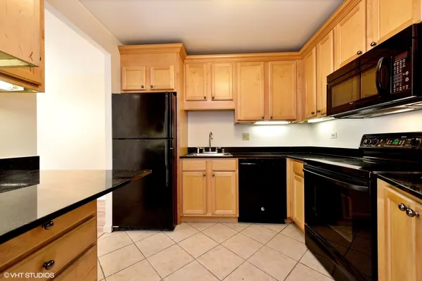 a kitchen with a refrigerator and a stove top oven