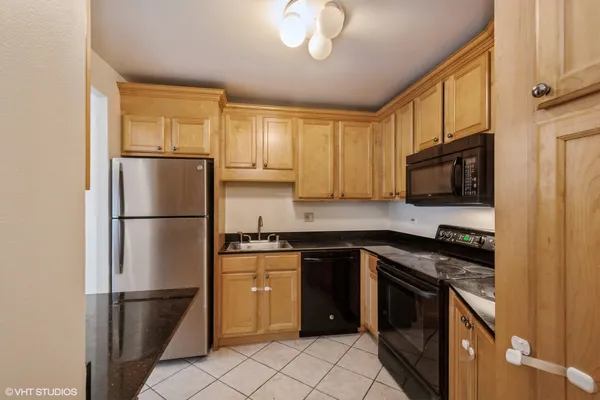 a kitchen with stainless steel appliances granite countertop a refrigerator stove top oven and sink