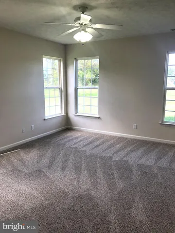 a view of a big room with windows and chandelier fan