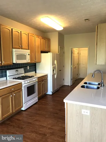 a kitchen with a stove a sink and a microwave